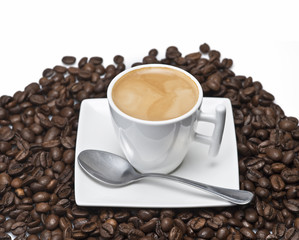 Café espresso sobre un montón de granos de café.