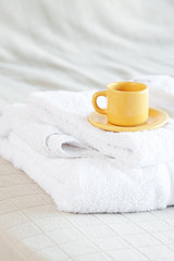 cup lying on towels on the bed