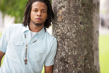 Man leaning on a tree