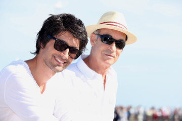Two men in white tops and sunglasses