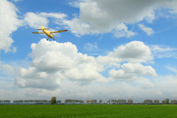 Yellow Aircraft against Overcast Sky - obrazy, fototapety, plakaty