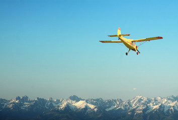 Yellow Aircraft and the Mountains - obrazy, fototapety, plakaty