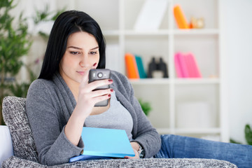 woman reading message on mobile phone