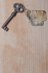 Antiker Schlüssel mit Anhänger auf Holz