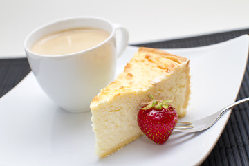 Käsekuchen mit Erdbeere und Kaffetasse