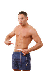 Fototapeta premium A muscular man measuring his waist