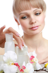 Obraz na płótnie Canvas A young woman applying cosmetics, focus on her hand
