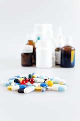tablets and liquid drugs in bottles on light background