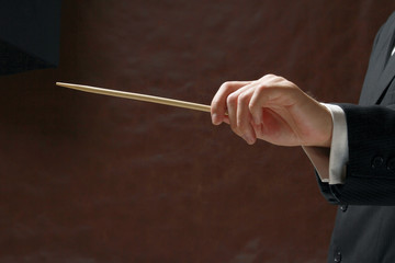 A concert conductor's hand with a baton
