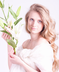 Beautiful young woman with white lily on white background