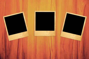 Blank instant photo frames on old wooden background.