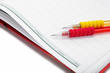 Two automatic pencil in the diary on a white background.