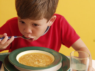 Niño comiendo sopa con fideos, niño almorzando.