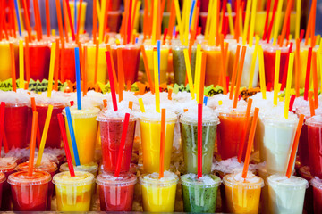Colorful natural fresh fruits juice glasses with straw