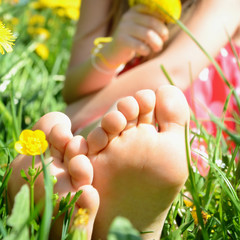Kinderfüße in der Blumenwiese