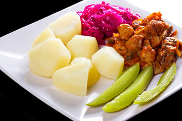 Meatballs in tomato sauce with potatoes and salad