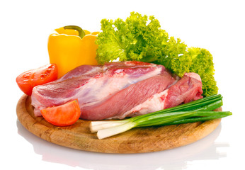 Raw meat and vegetables on a wooden board isolated on whitе