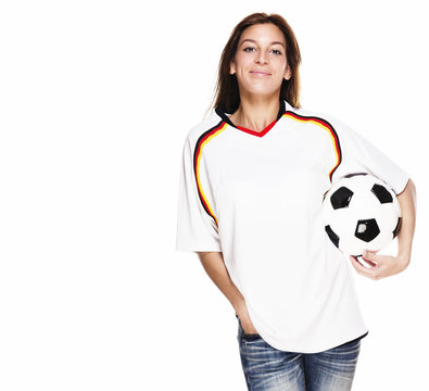lachende junge frau in fussball trikot mit fu&szlig;ball unter dem arm