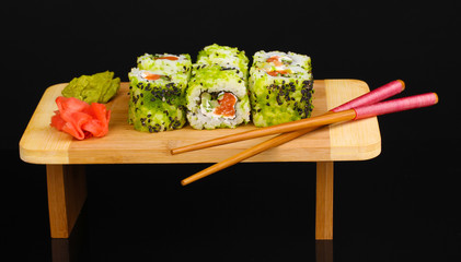 Tasty rolls served on wooden plate isolated on black