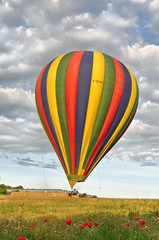 Naklejka premium Montgolfière dans un champ de coquelicots