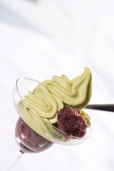 clear cup of green tea ice cream with red bean topping