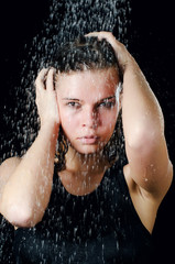 Obraz premium The girl under a shower on the black