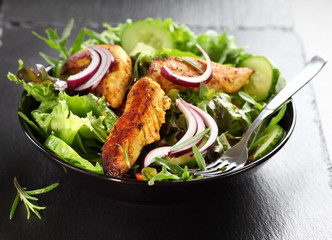 Salad with marinated chicken breast stripes