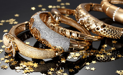 Beautiful golden bracelets on grey background