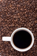 White coffee cup on coffee beans