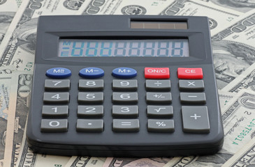 calculator on heap of one hundred dollars banknotes