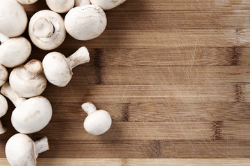 Fresh champignons at the old cutting board with copy space