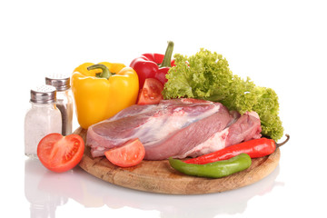 Raw meat and vegetables on a wooden board isolated on whitе