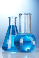 Test-tubes with blue liquid on blue background