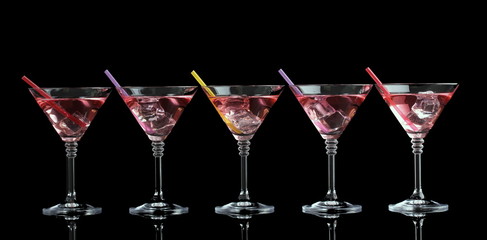 Red cocktail in martini glasses isolated on black