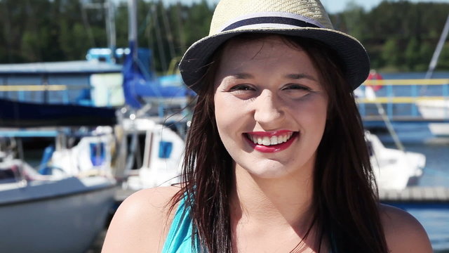 Beautiful young woman in yacht harbor. Happy girl in front of ya