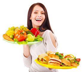 Woman choosing between fruit and hamburger.