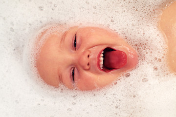Fototapeta premium happy baby face in bubble bath