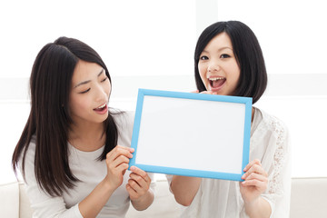 Beautiful young women with message board