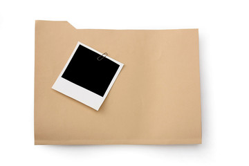Blank instant print clipped to manila folder