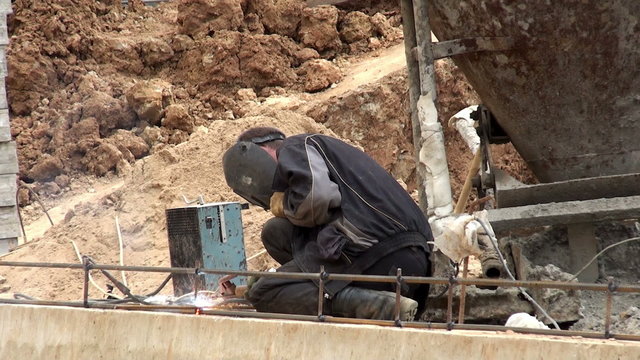Workers at a construction site. Welding of metal.