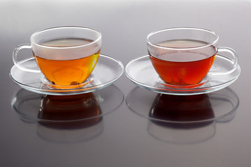 Transparent cup with green and black tea