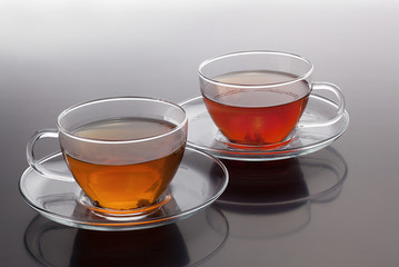 Transparent cup with green and black tea