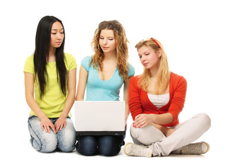 Three girls sitting on the floor with a laptop