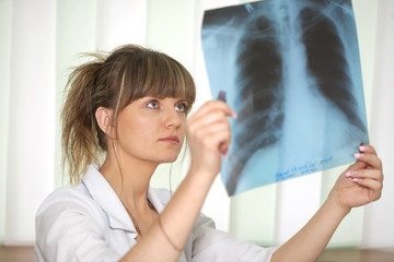 Sickness. Female doctor examining an x-ray
