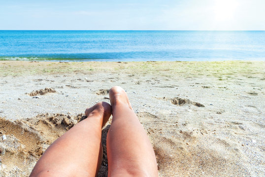 wet female feet on the beach and sand