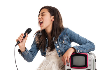 Preteen girl singing karaoke with microphone isolated on white - obrazy, fototapety, plakaty