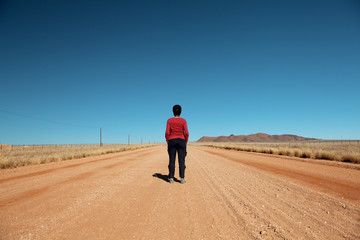 woman front back in the desert road