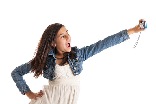 Preteen girl taking picture of herself isolated on white