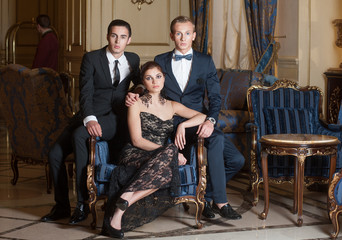 Two men and woman posing for group photo in luxury interior