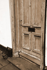 Fototapeta na wymiar Wooden door with a mail slot in sepia